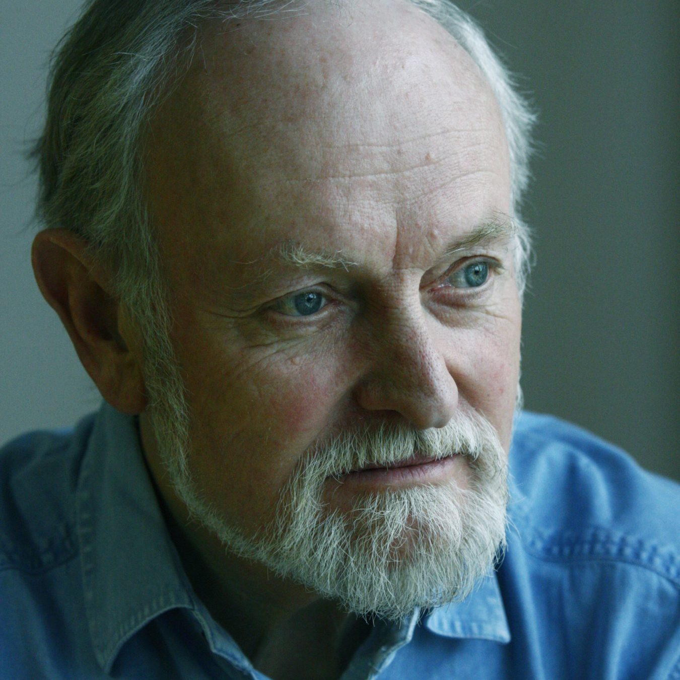 Headshot photo of Sir Richard Stilgoe, wearning blue shirt